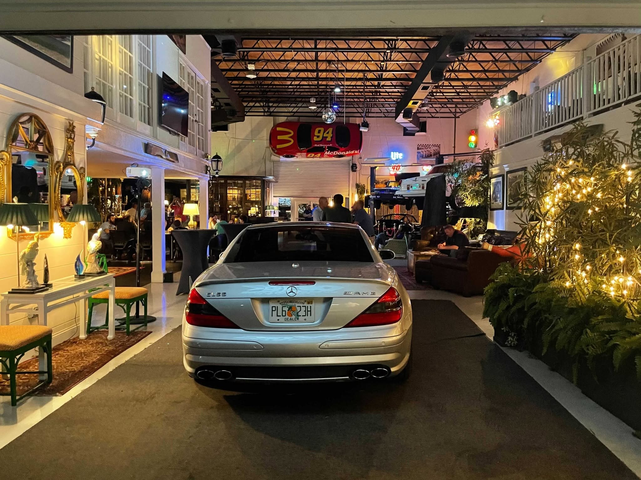 A silver Mercedes parked among lounge seating during an evening event at 51 Club
